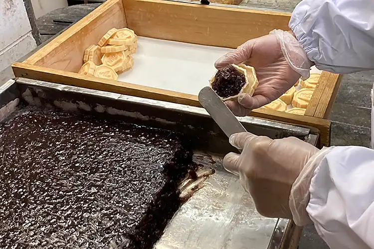 じっくりと煮詰めた赤あずきを水無瀬駒1つ1つに詰めます