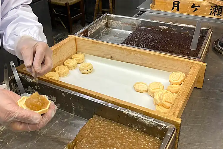 じっくりと煮詰めた白あずきを水無瀬駒1つ1つに詰めます